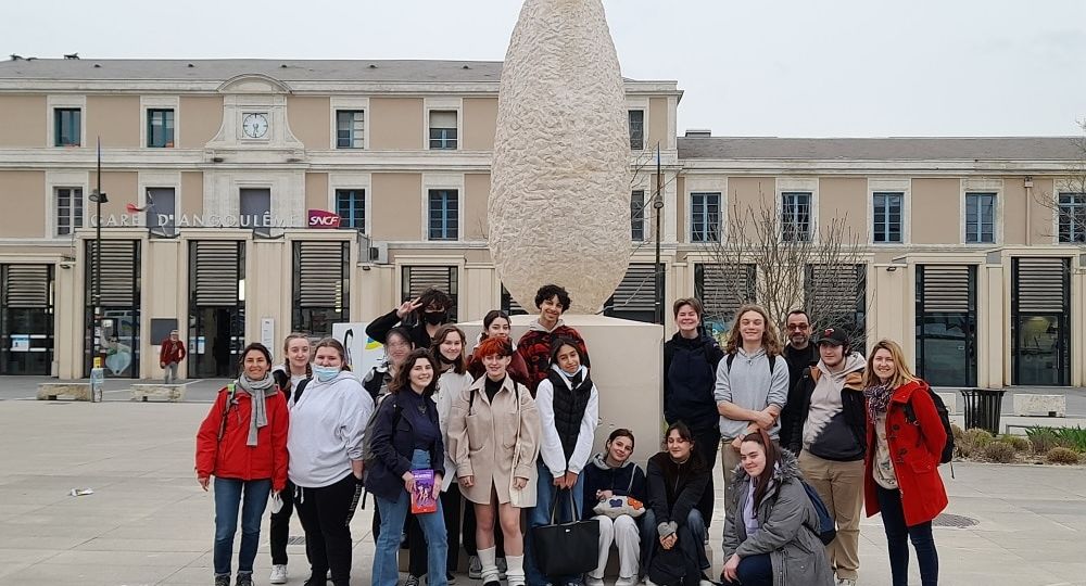 Devant le menhir, sur le parvis de la gare